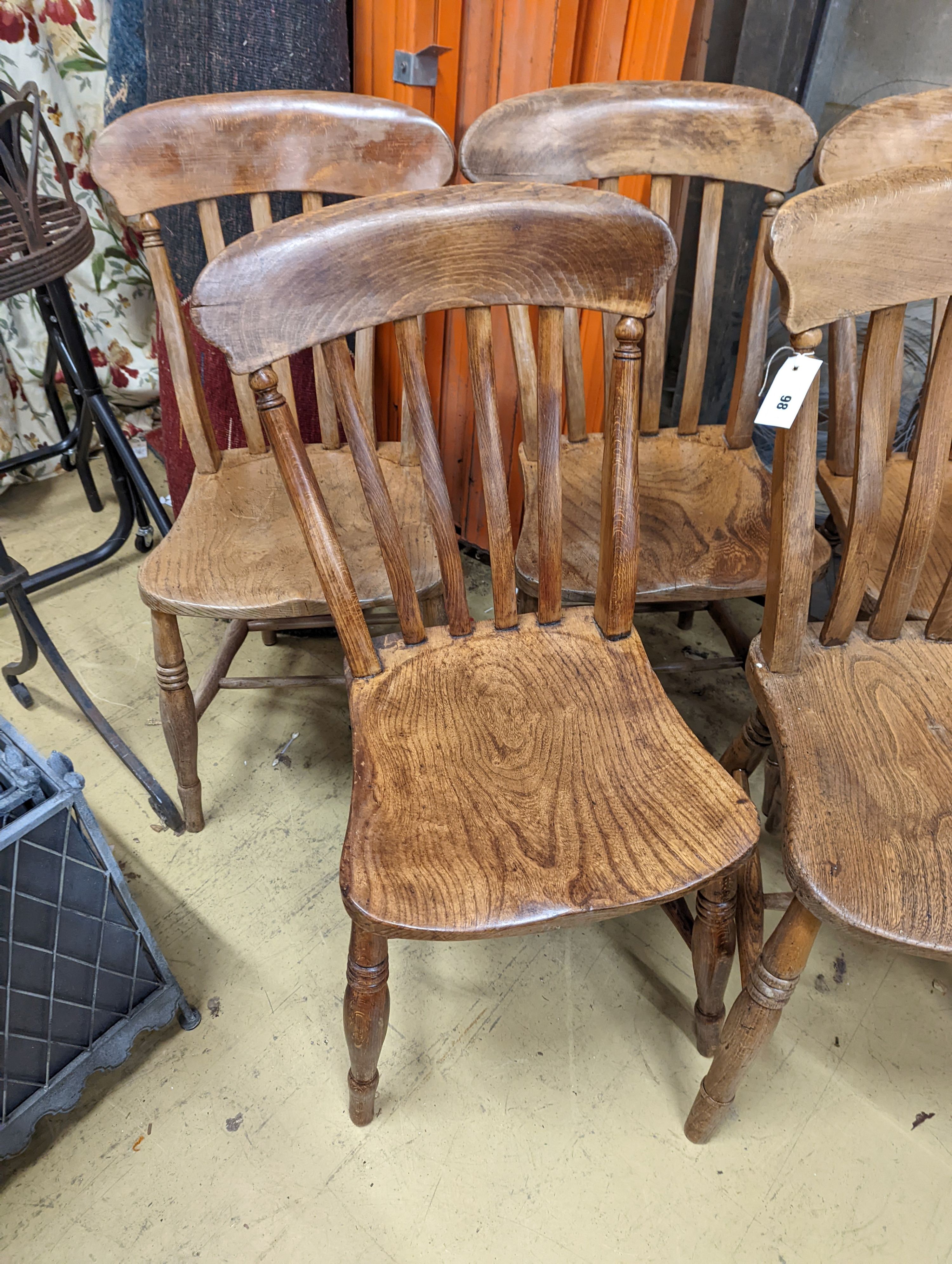 A harlequin set of six Victorian elm and beech Windsor lathe back kitchen chairs